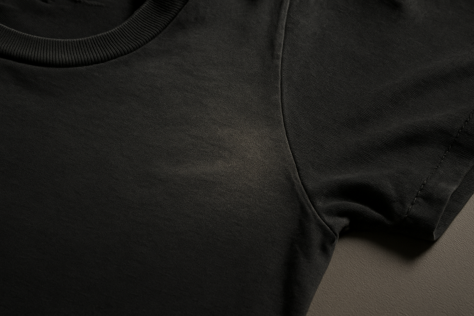 Macro view of underarm deodorant stains on dark cotton fabric, illustrating how to grade deodorant stains on clothing